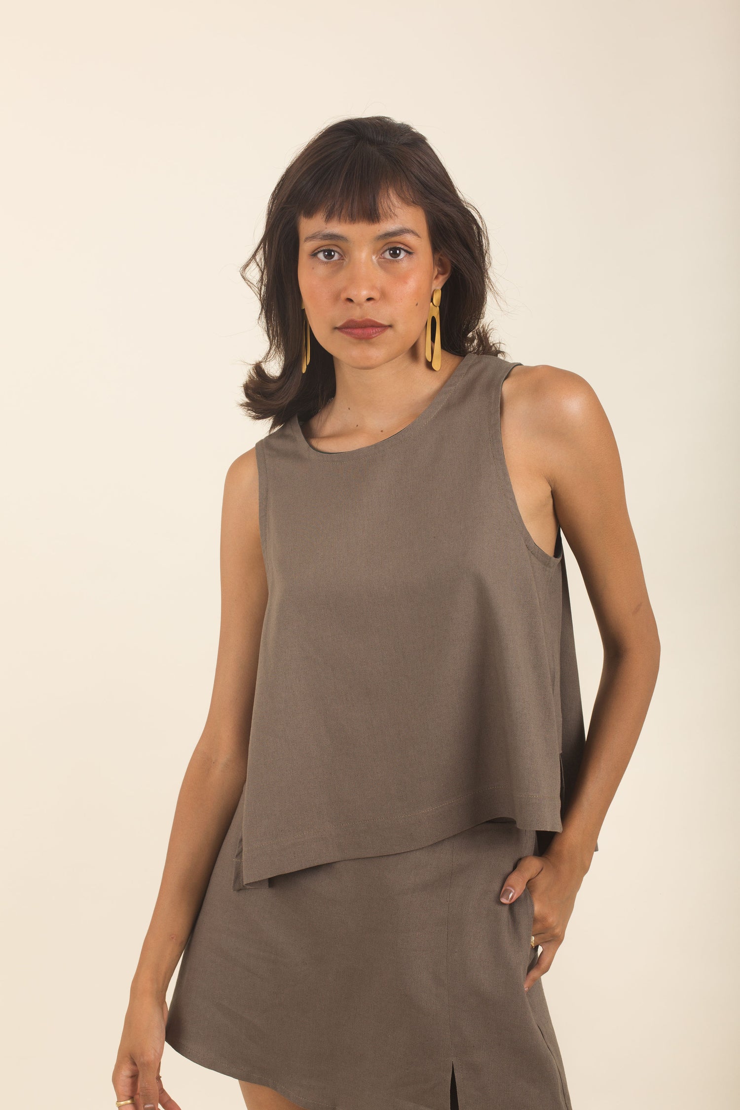 Blusa de lino marron cafe sin mangas con cuello redondo, bias, panel lateral y corte asimétrico. Holgada y fresca.